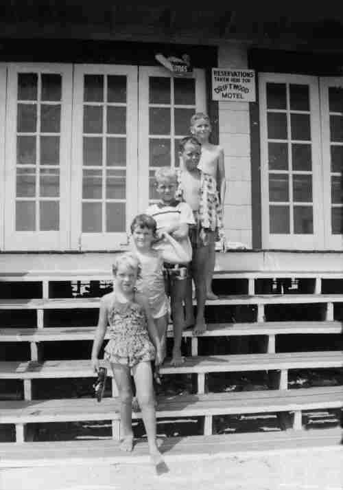 The kids standing on the stairs of the closed beach grill