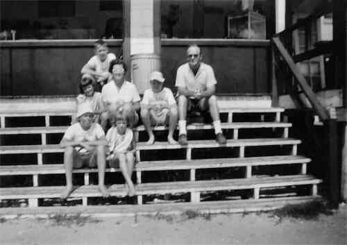 The family sitting on the stairs of the open beach grill